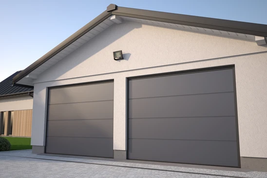 Garage résidentiel moderne avec porte sectionnelle blanche installée, rails de guidage horizontaux et mécanisme d'ouverture automatique apparent au plafond